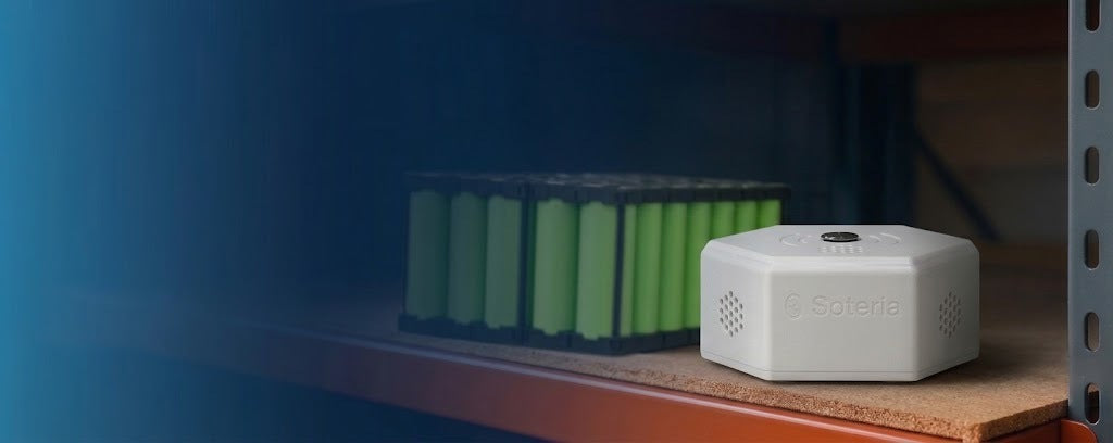 Soteria Sense sitting on a warehouse shelf beside a lithium-ion battery pack